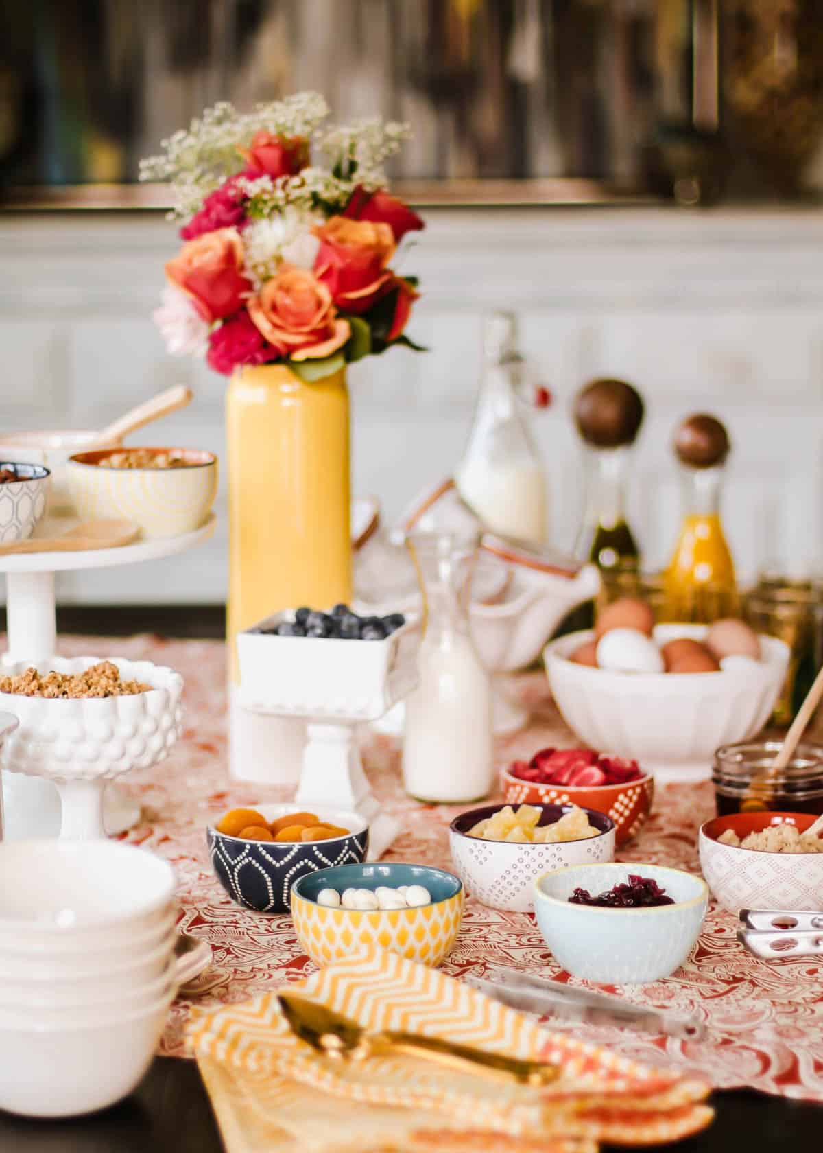 table set up with lots of bowls filled with toppings for oatmeal bar.