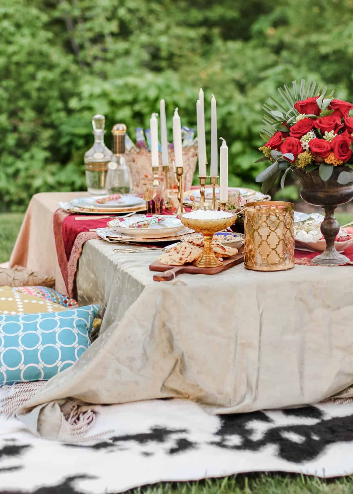 Moroccan themed table setting outdoors with floor seating.