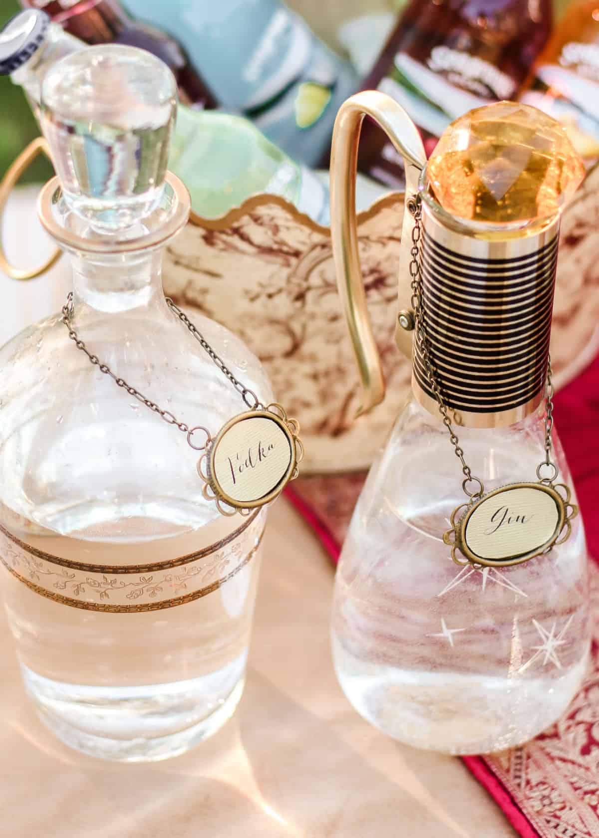 vintage glass carafes with liqueur tags around the neck.