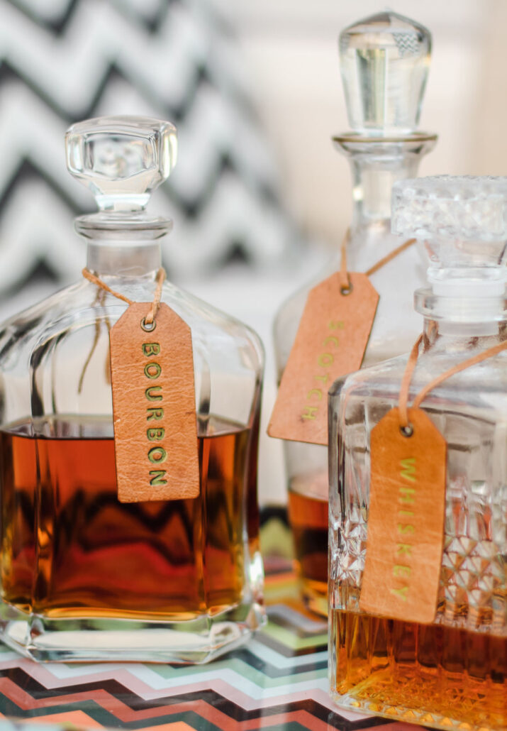 whiskey and bourbon decanters with leather tags.