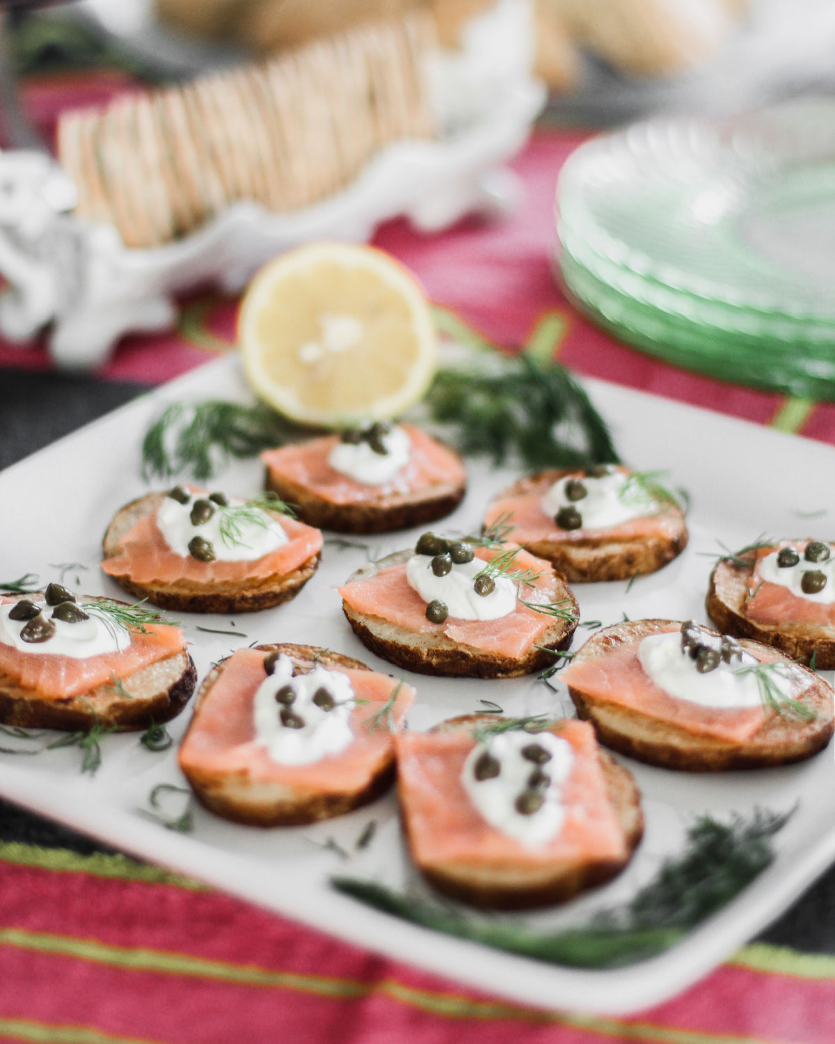 salmon on potato slices topped with sour cream and capers.