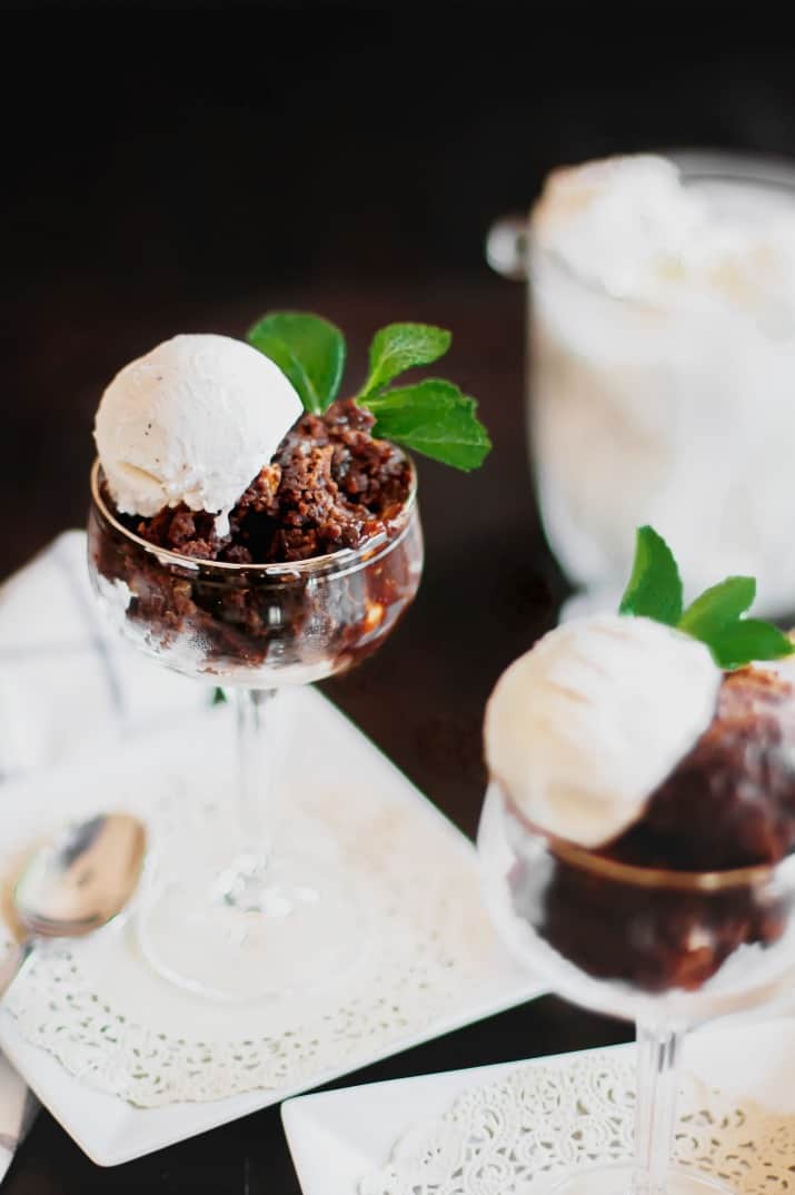 Slow cooker brownie cake scooped into glass and topped with ice cream
