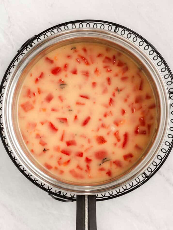adding red peppers and liquids to saucepan.