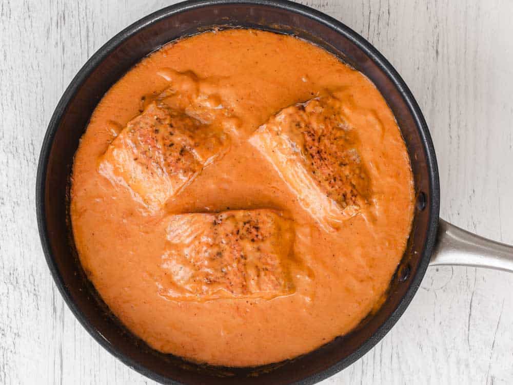 salmon in red sauce in large skillet.