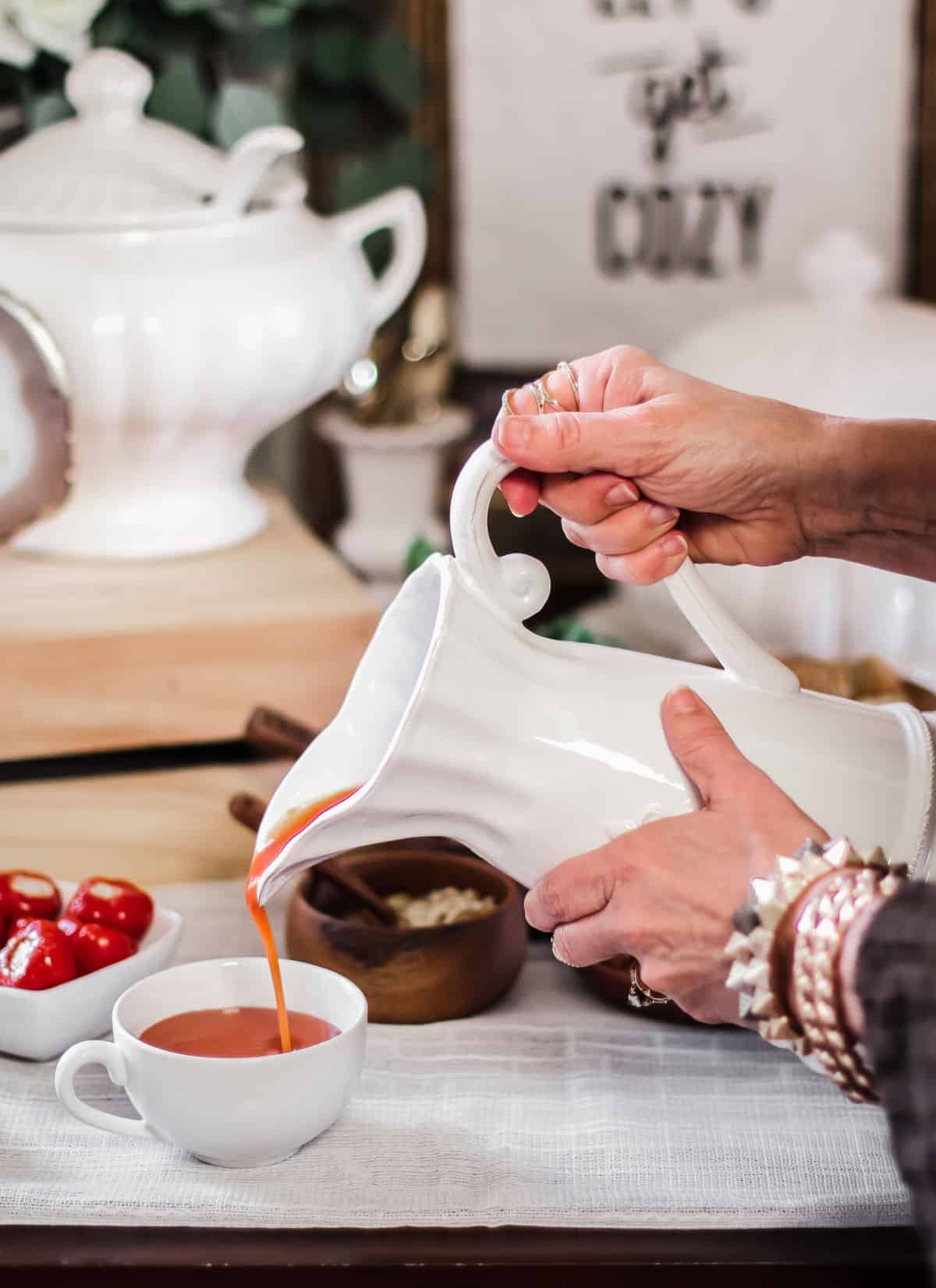 pouring tomato soup from pitcher into tea cup