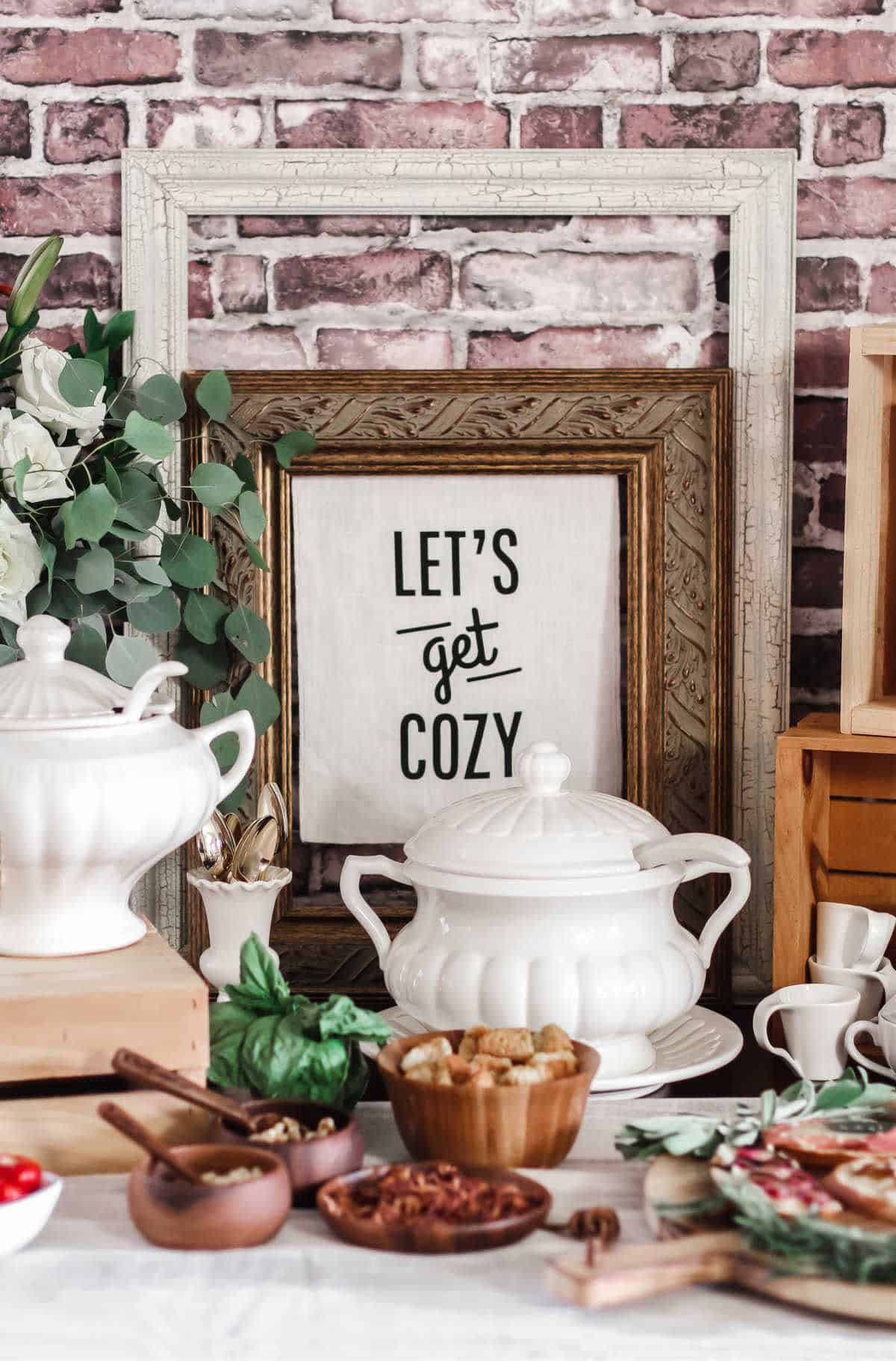 food buffet with tureens and "lets get cozy" sign