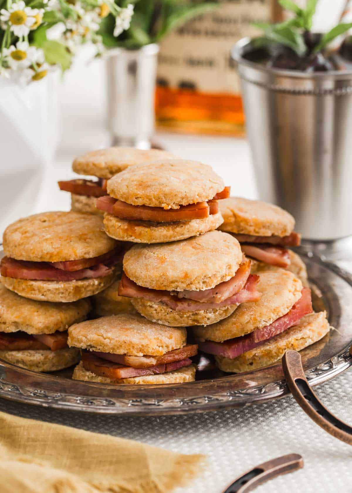 ham and sweet potato biscuits piled on a silver platter, ready for a party.