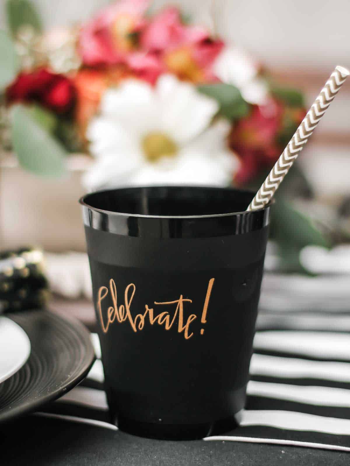 black cup with Celebrate written in gold on the side.