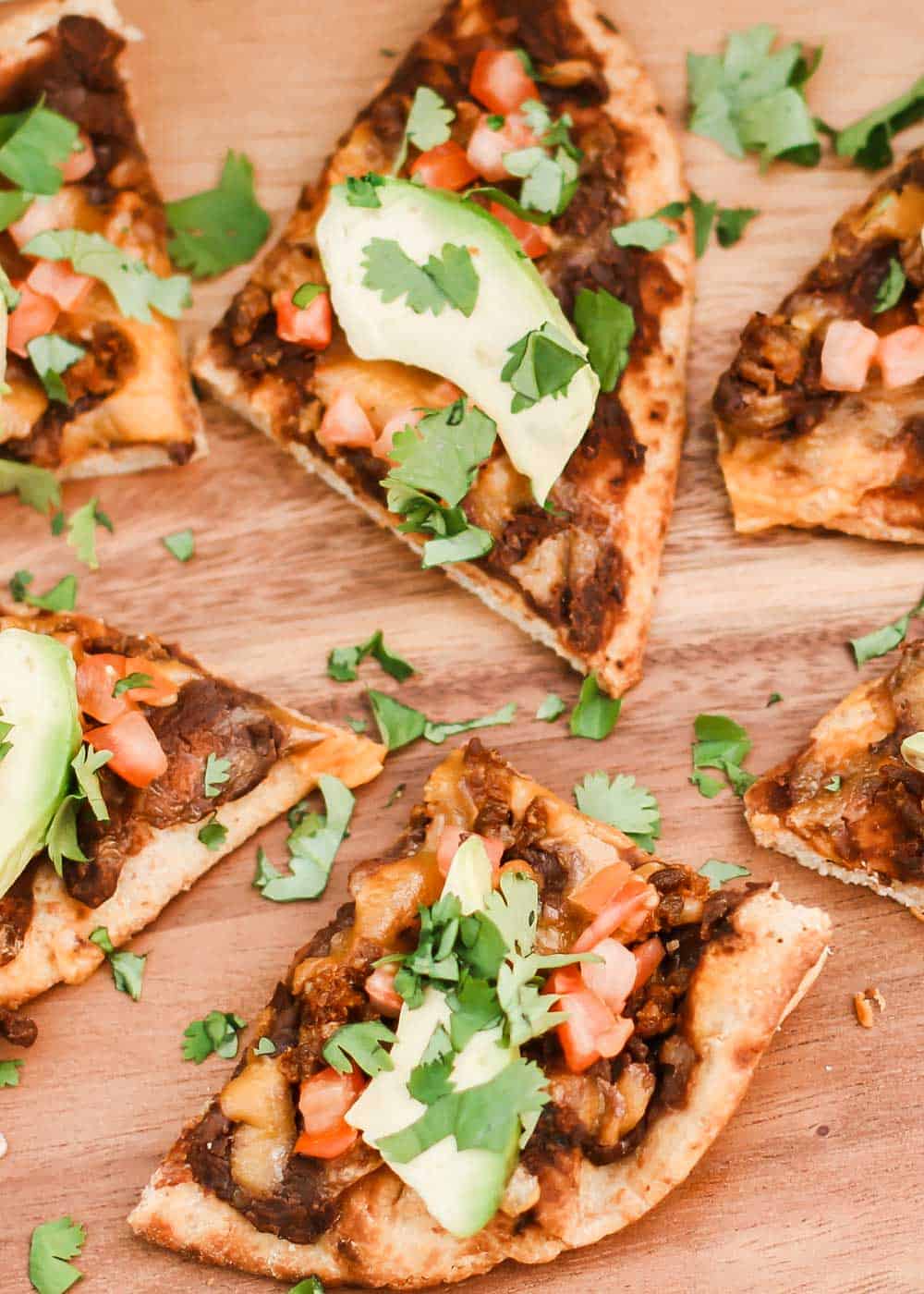 slices of chorizo flatbread pizza on wood board.