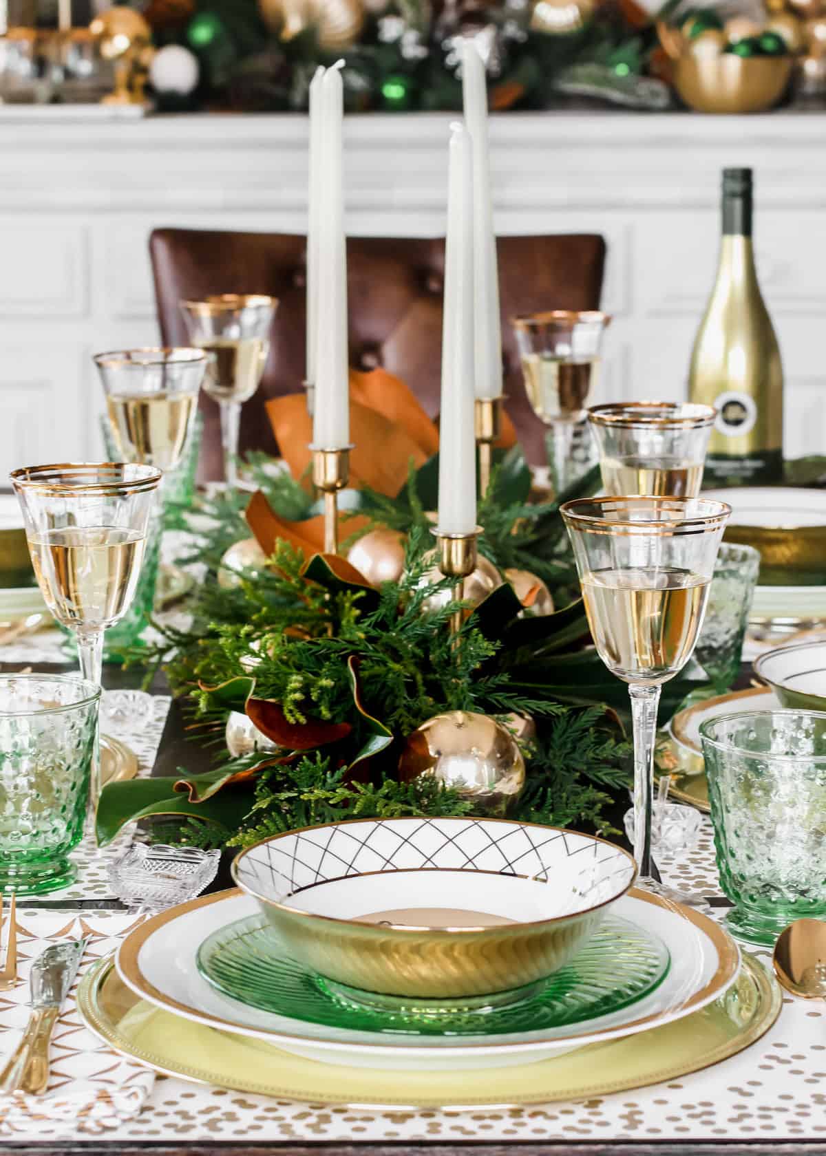 Christmas table setting with green and gold place settings and decoration.