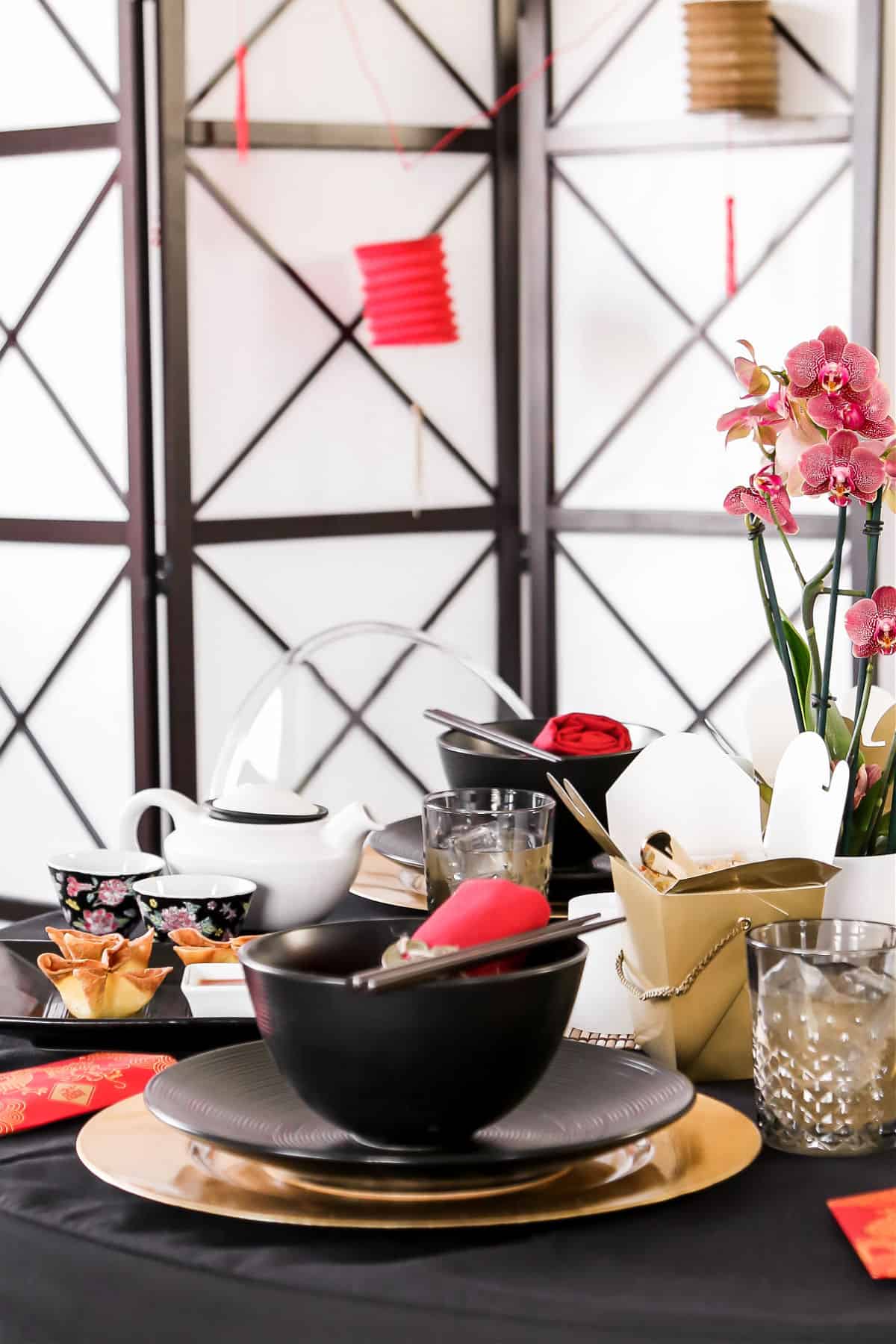 Table setting for Chinese theme dinner party, with red and black and gold decor