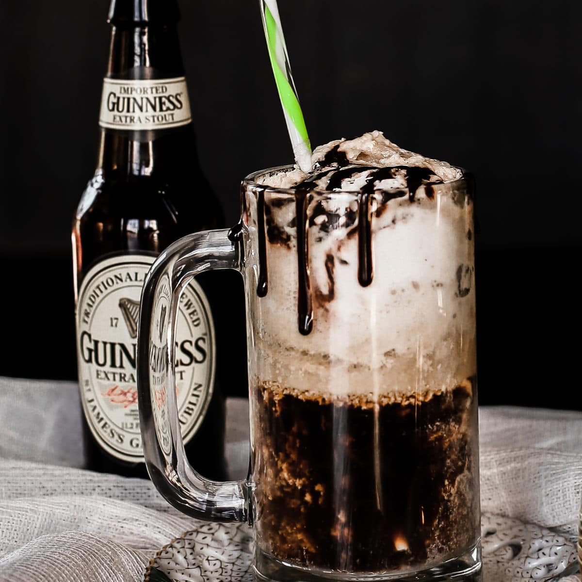 beer mug with ice cream beer float and Guinness bottle in background.