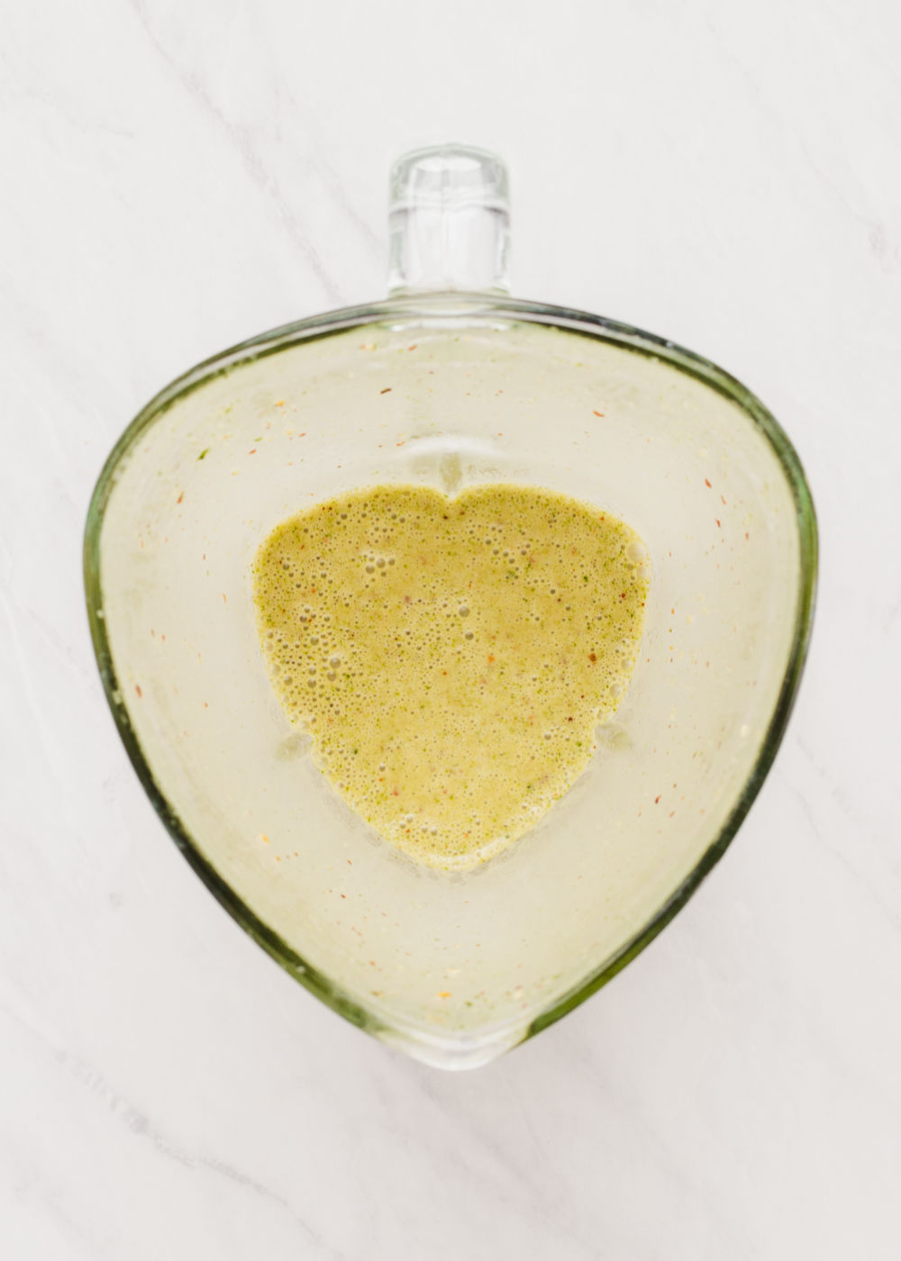 green dressing blended up in a blender.