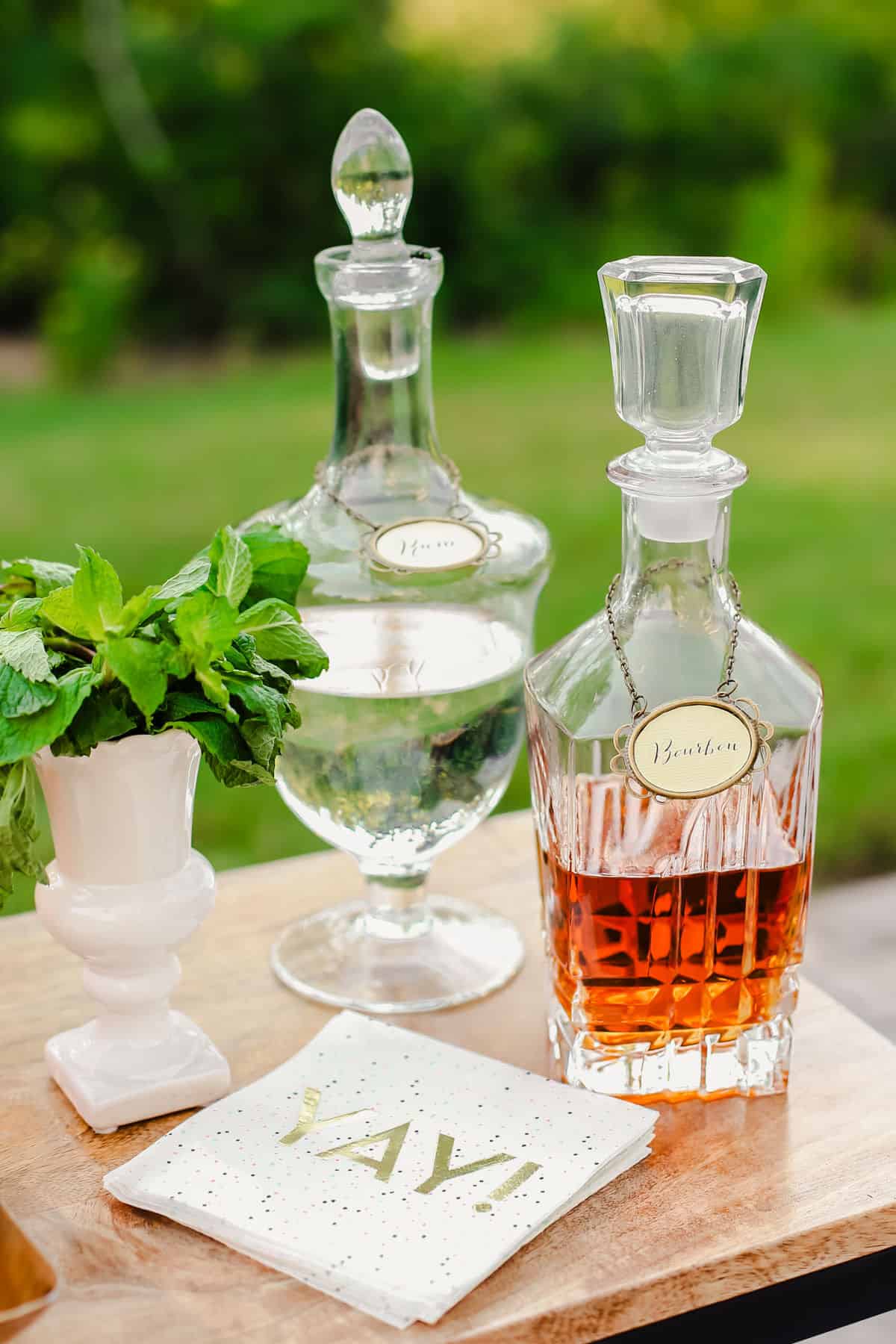 decanter bottles of rum and liquor on table in outdoor setting.