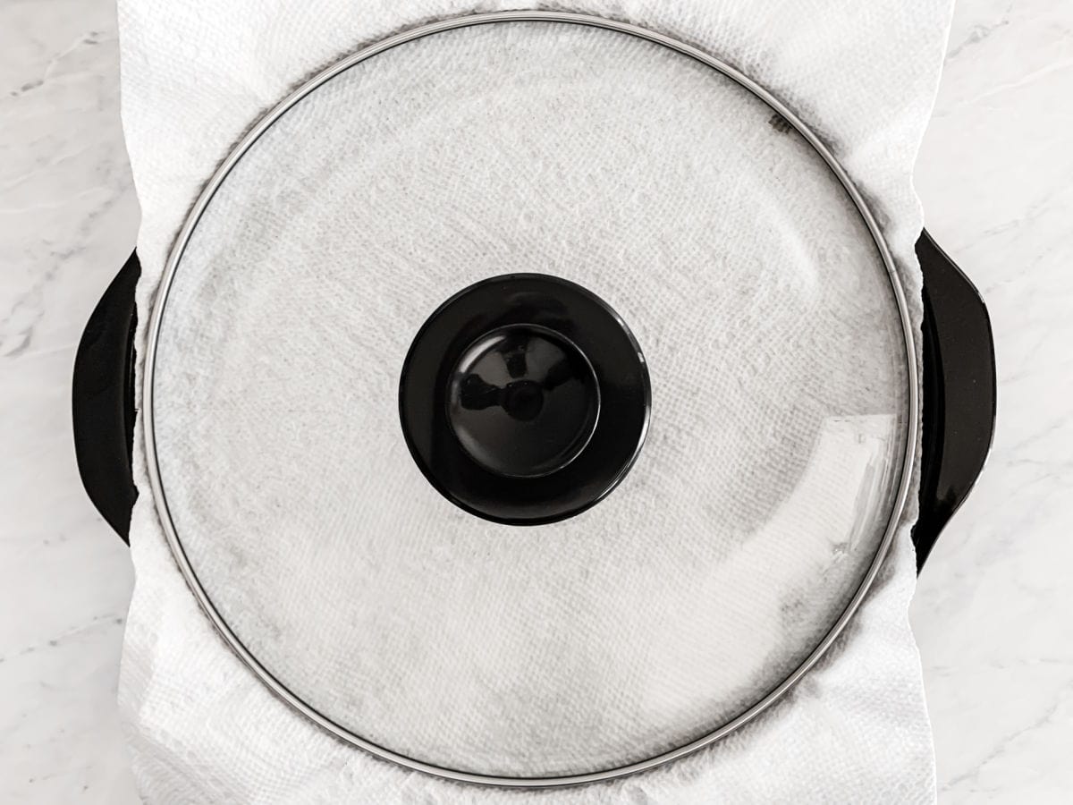 crock pot with paper towel and lid on top.