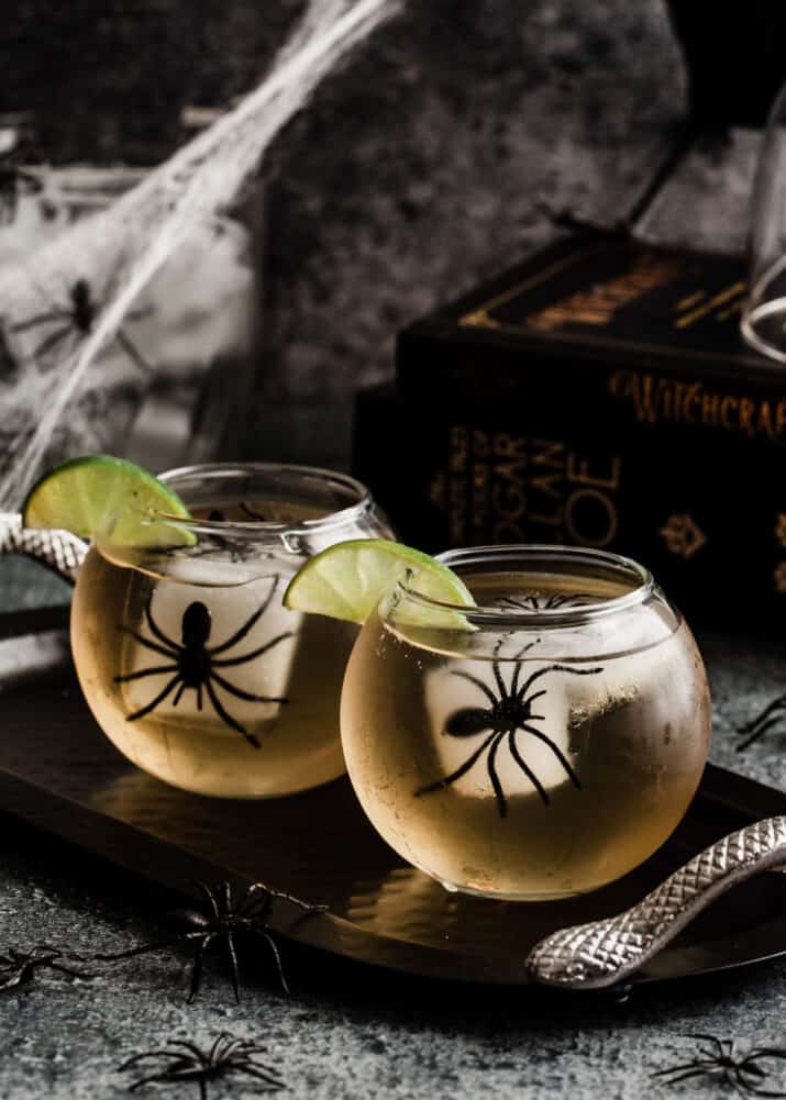 light colored drink in round glasses with spider ice cubes.