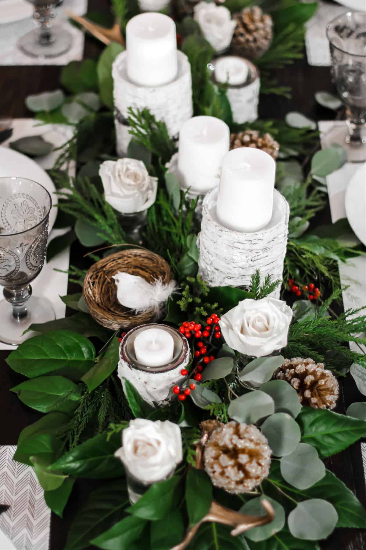 table centerpiece of greenery and white candles