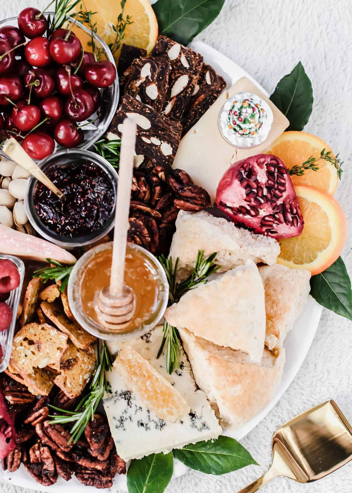 overhead view of breakfast charcuterie board with scones, cheese, fruit, jam and honey.