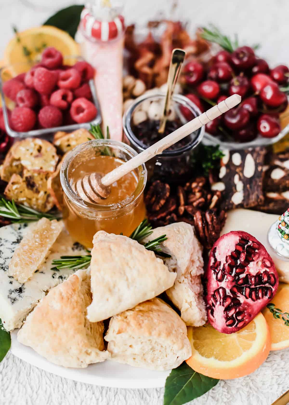 brunch cheese board with scones, honey, jam and fruit.