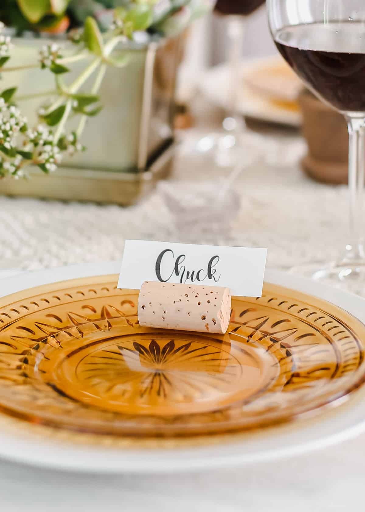 amber glass plate with cork place card holder on top.