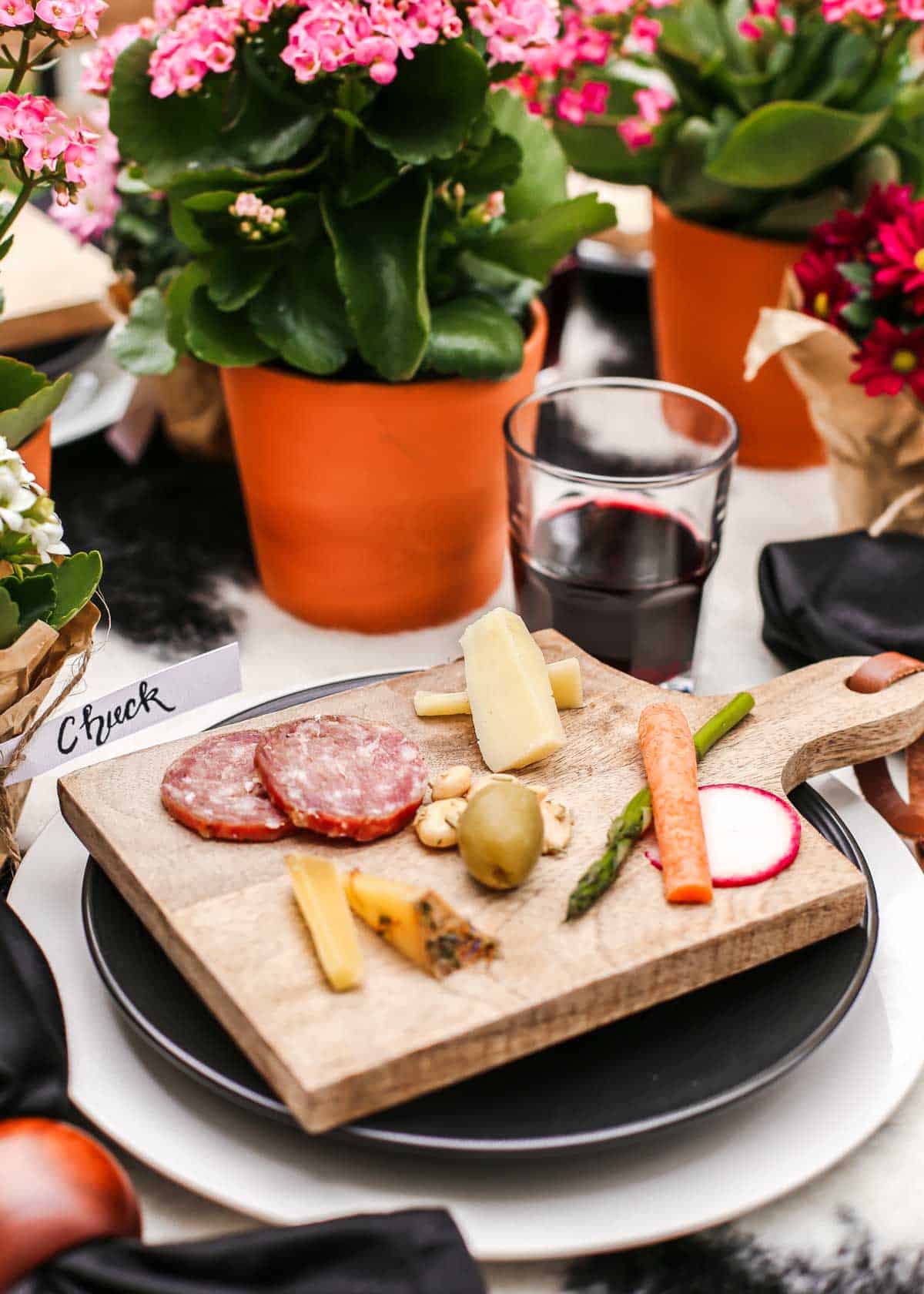 tablescape with individual charcuterie board placed on top of black and white layered plates.