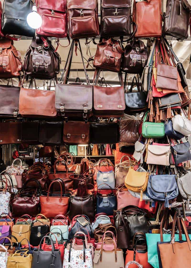 Street vendor market filled with leather bags.