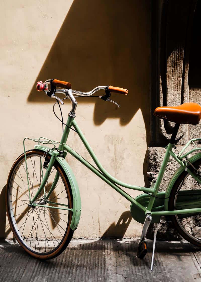 green bike on sidewalk in Florence, Italy.