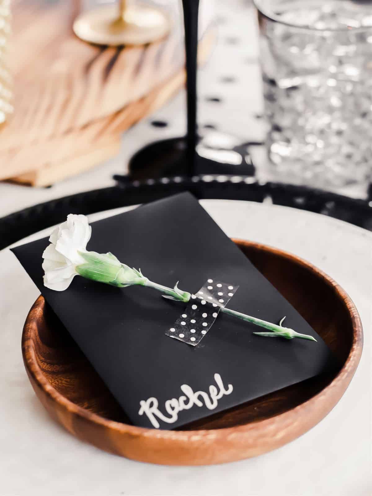 black place card with flower attached