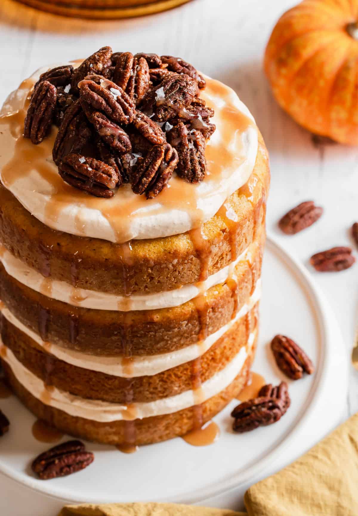 4 layer cake with candied pecans on top and caramel drizzle