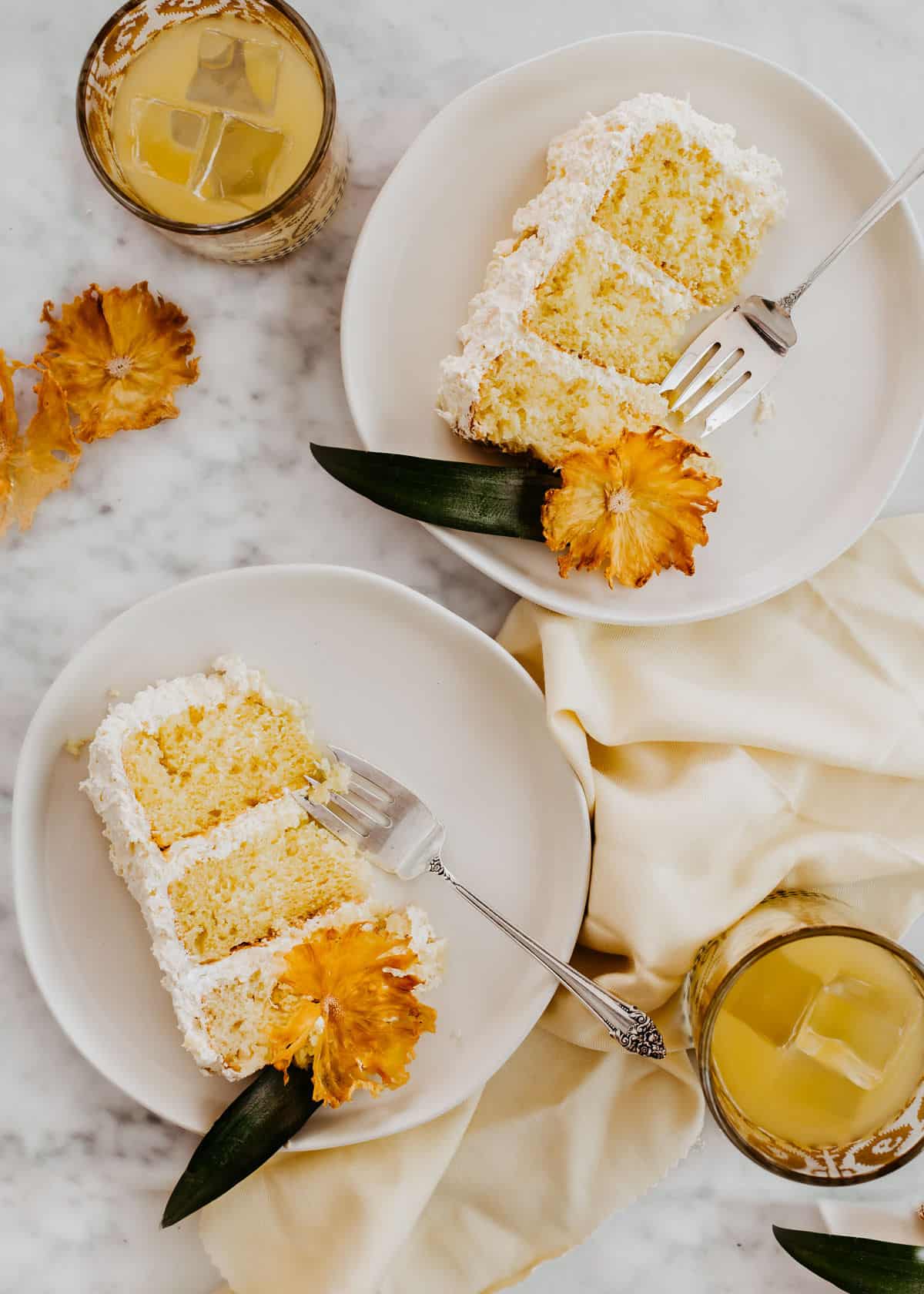 pineapple white layer cake slices on white plates.