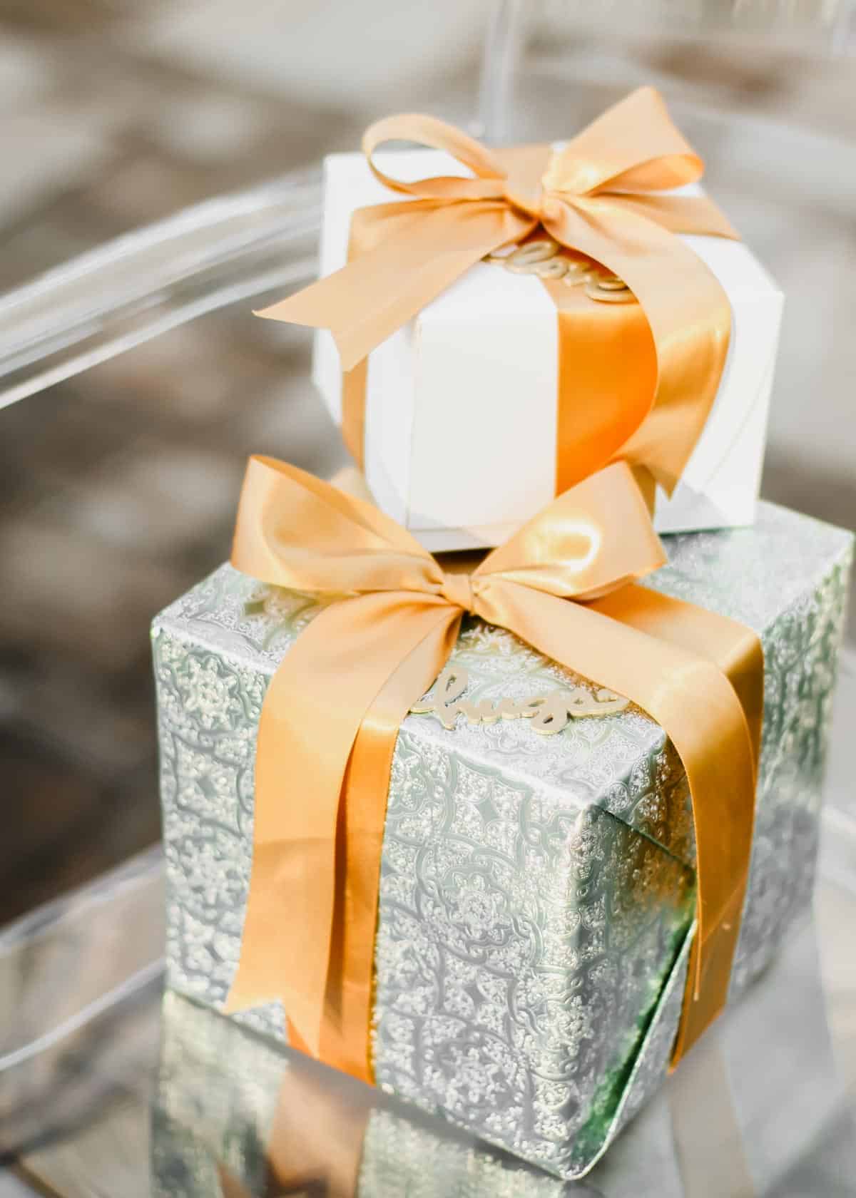 two wrapped gifts stacked, sitting on a chair.