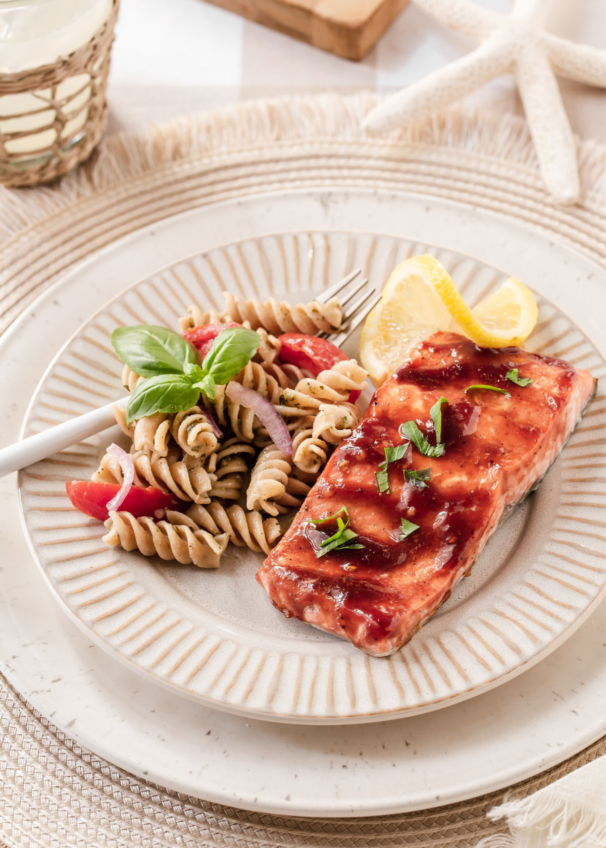 plate on table with salmon and pasta salad.