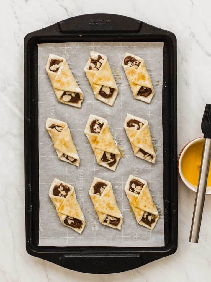pastry bites with egg wash on baking sheet ready to bake.