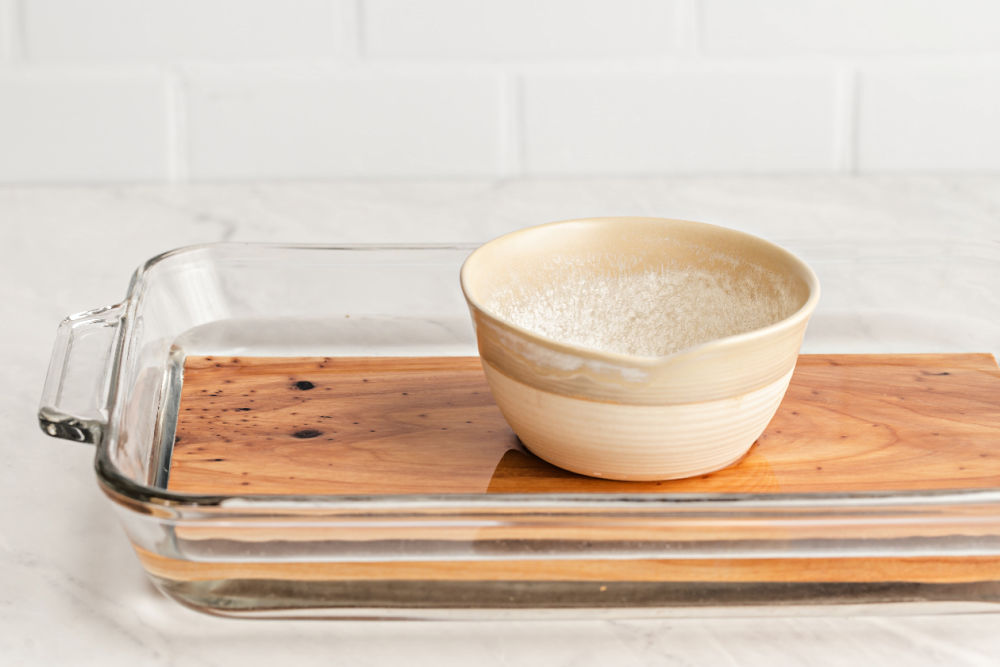 cedar plank soaking in water in glass dish.