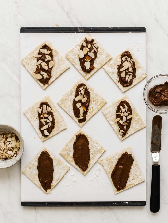 pastry squares with Nutella spread in the middle and almonds sprinkled on top. 