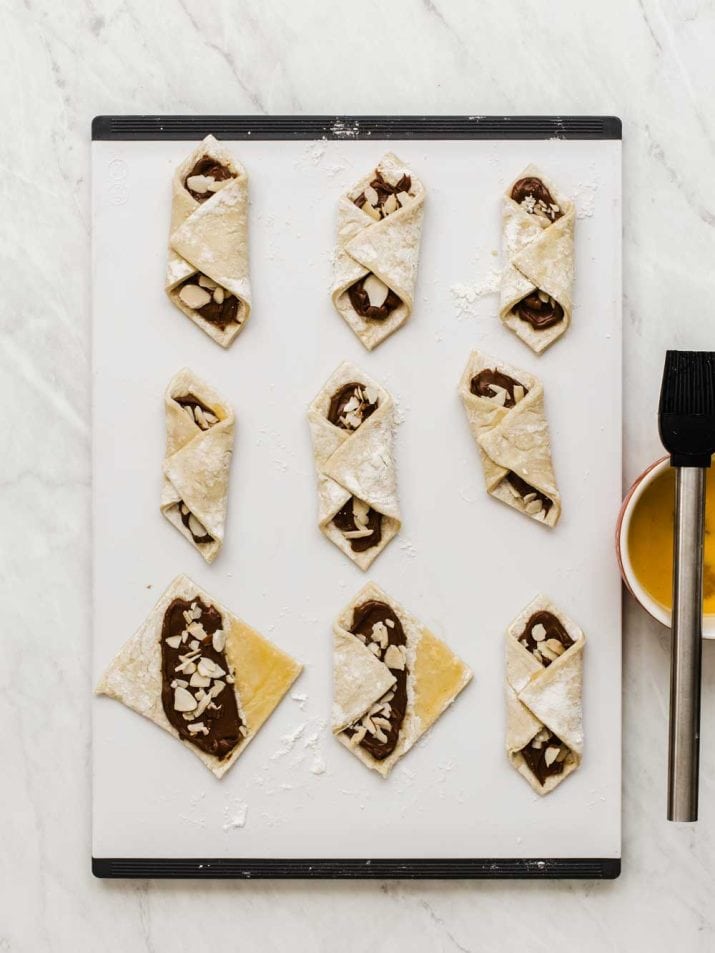 chocolate pastry packets on cutting board, folded like blankets.