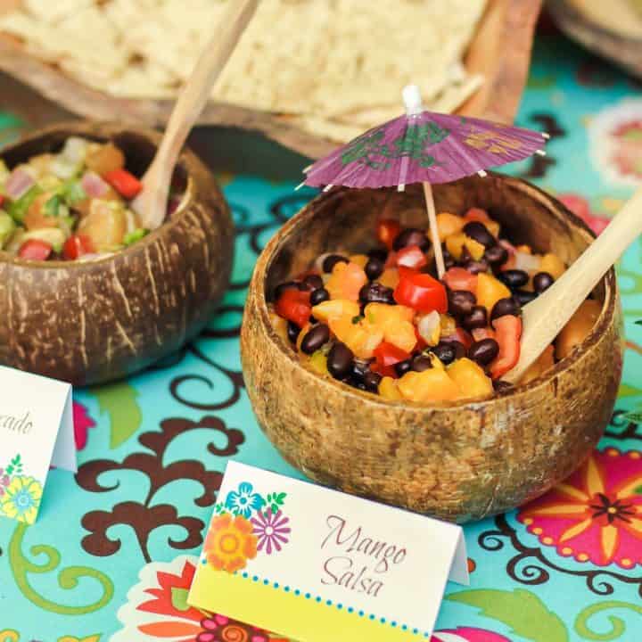 tropical fruit salsas served in coconut bowl with mini umbrella to decorate.