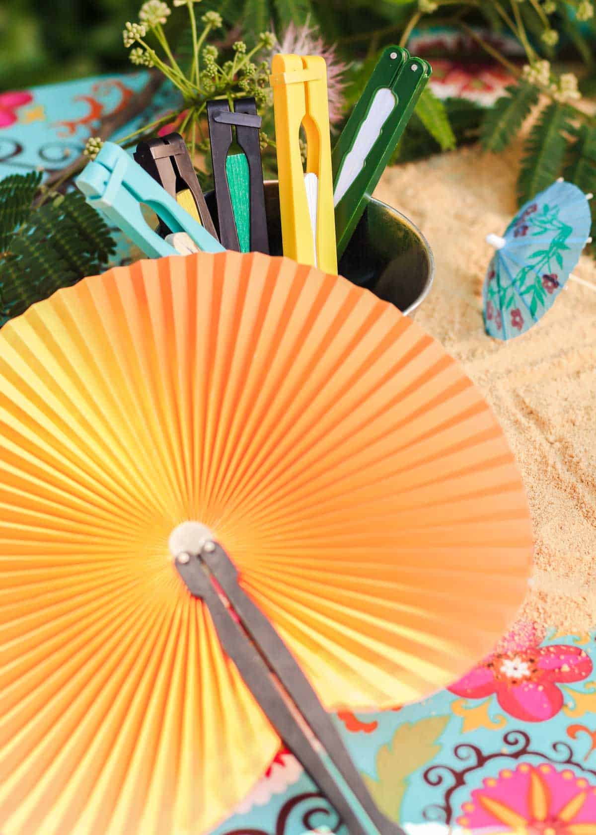colorful paper fans in bucket and one open fan.