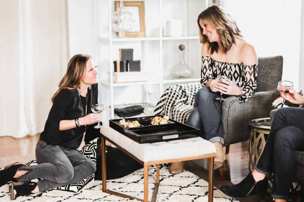 ladies sitting and chatting with drinks in hand.