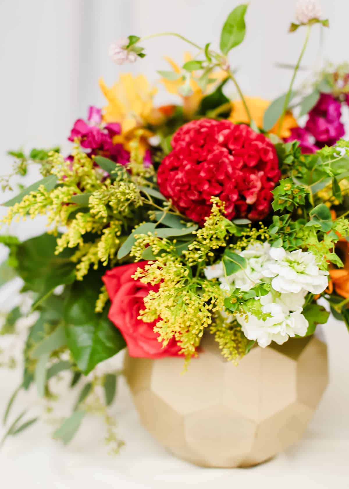 bright summer flowers in gold vase.