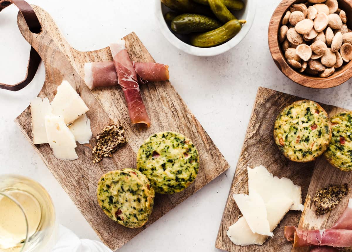 mini wood boards with charcuterie and cheese with pickles and almonds on the side.