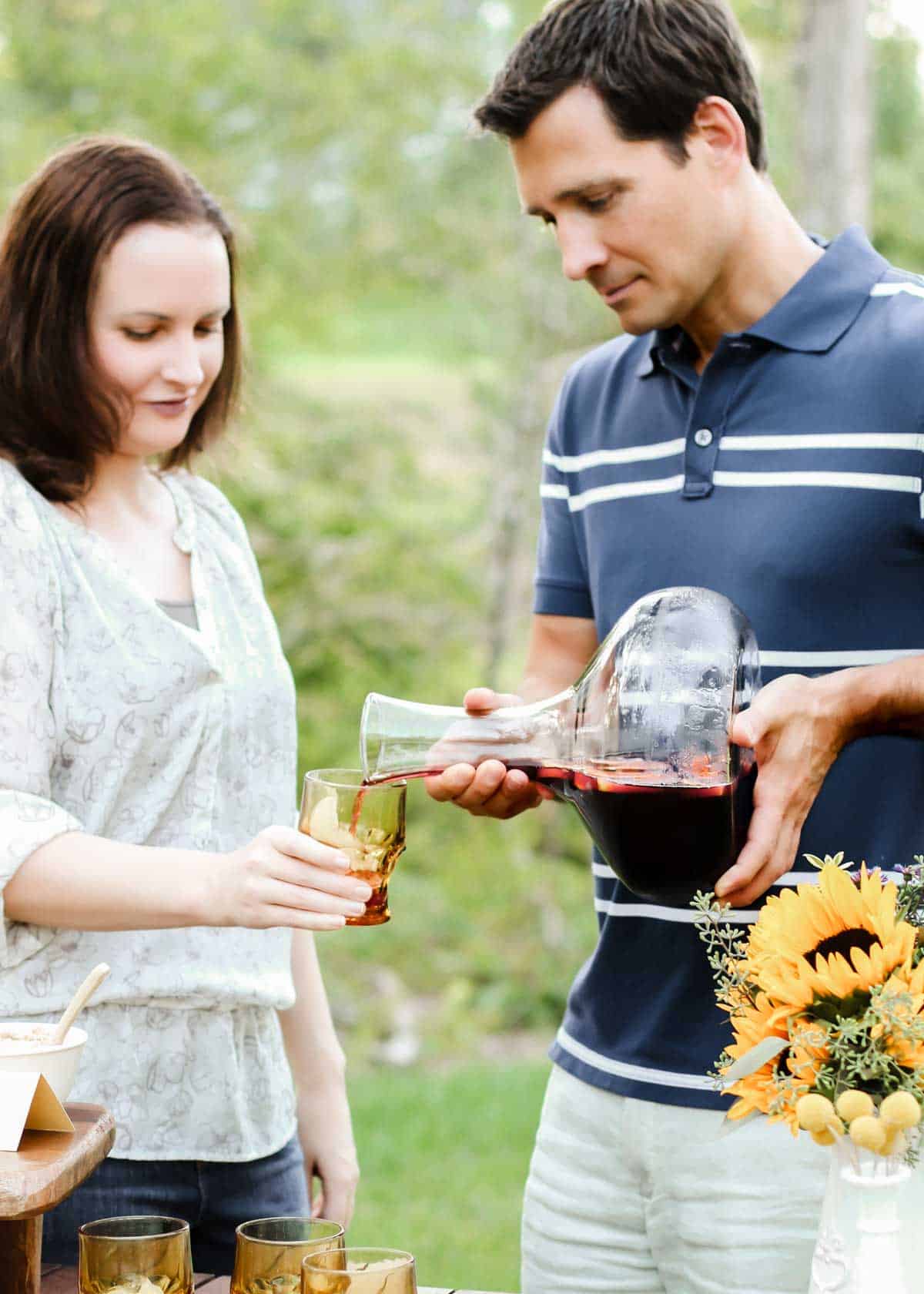 man pouring sangria into woman's glass.