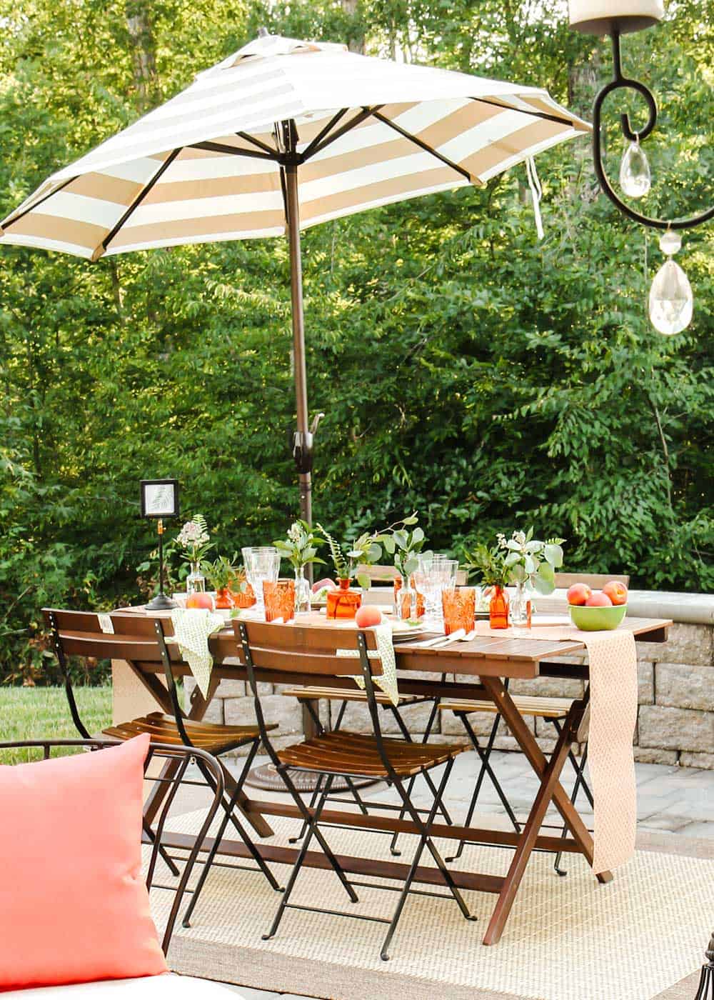 outdoor dining tablescape with umbrella for shade.