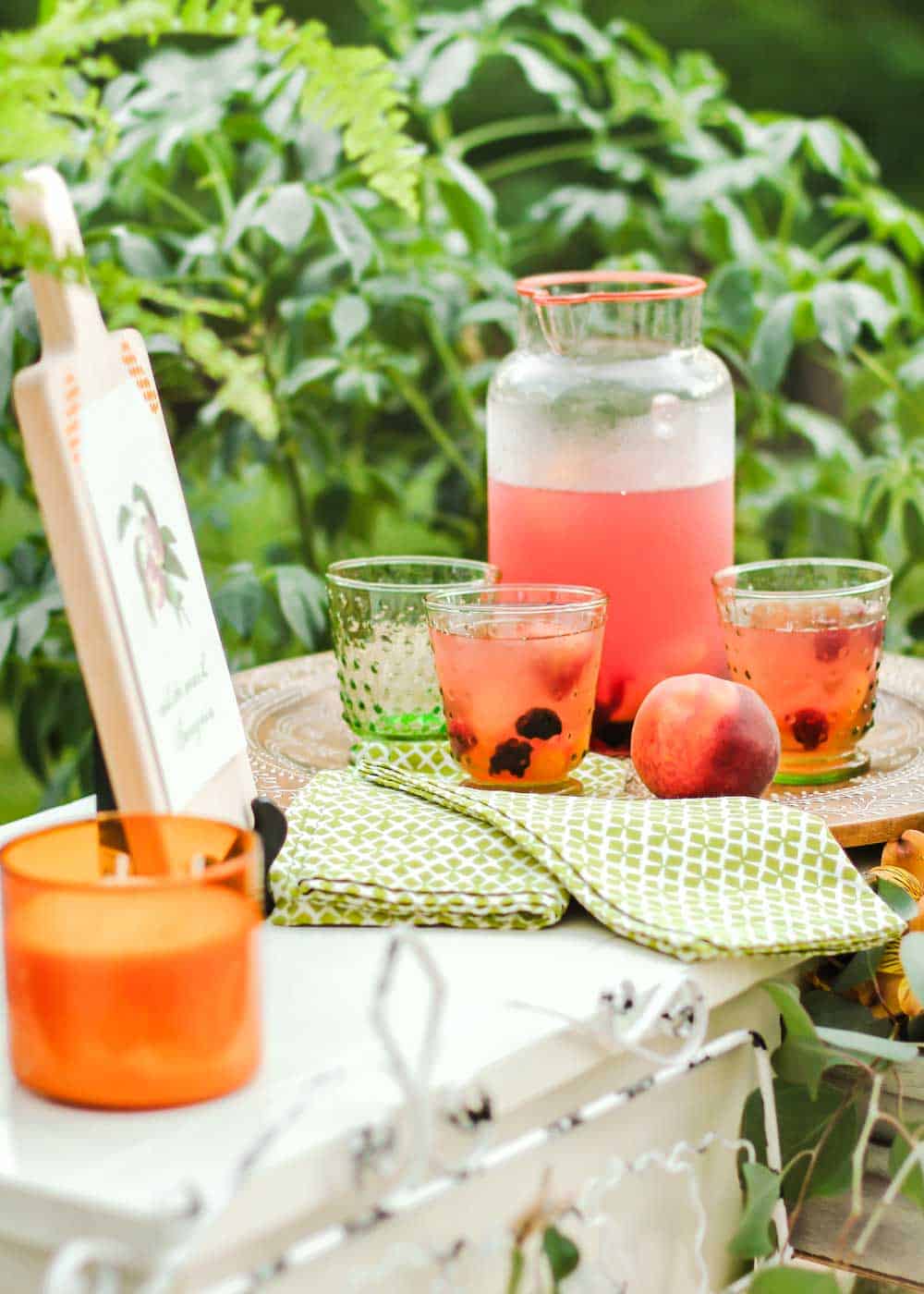 outdoor party table with pitcher of peach sangria.