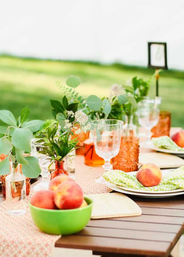 summer tablescape outside, decorated with orange and green.