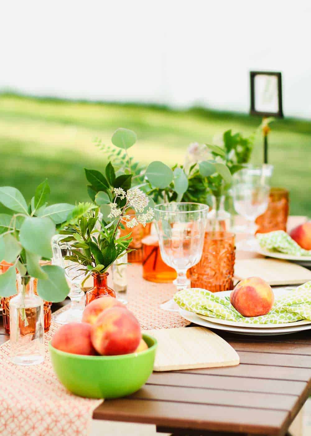 summer tablescape outside, decorated with orange and green.