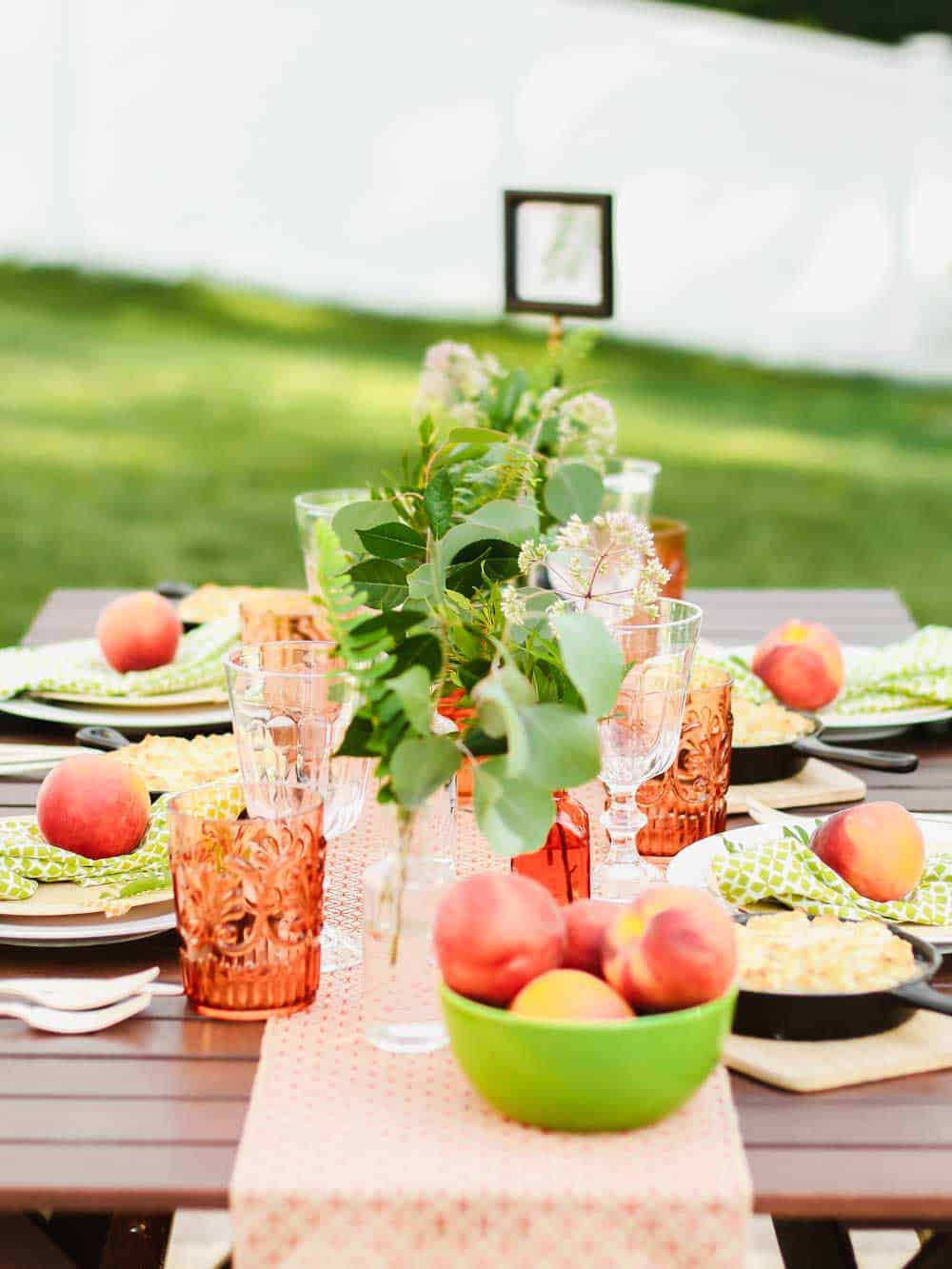 summer tablescape outside, decorated with orange and green.
