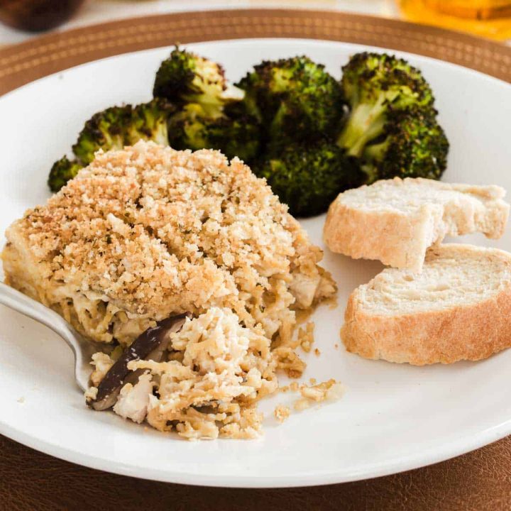 chicken tetrazzini on plate with broccoli and bread.