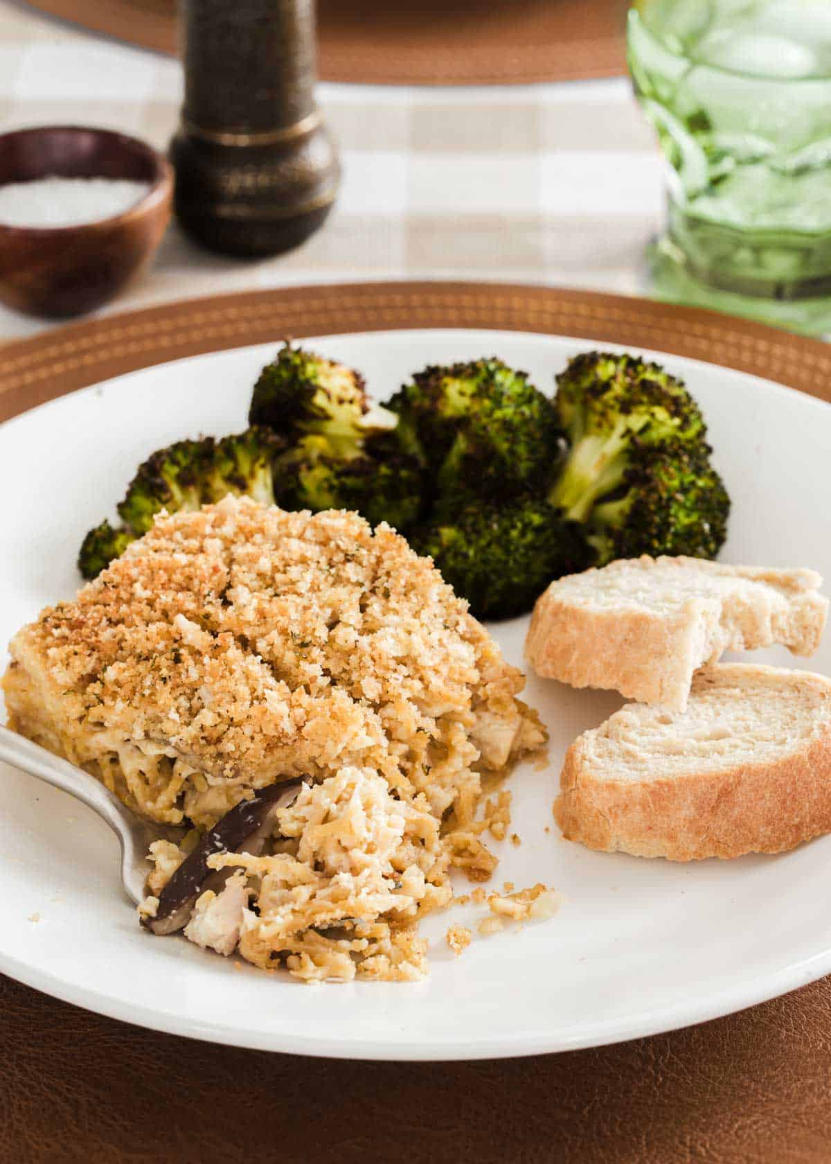 chicken tetrazzini on plate with broccoli and bread.