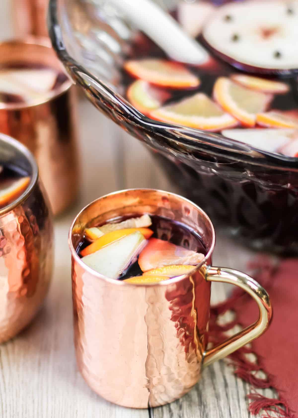 red sangria with fruit in copper cup.